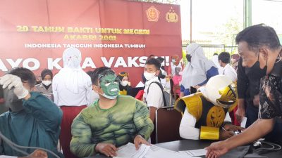 Petugas dari Polres Kendal yamg mendata peserta vaksinasi anak, menggunakan kostum ala super hero