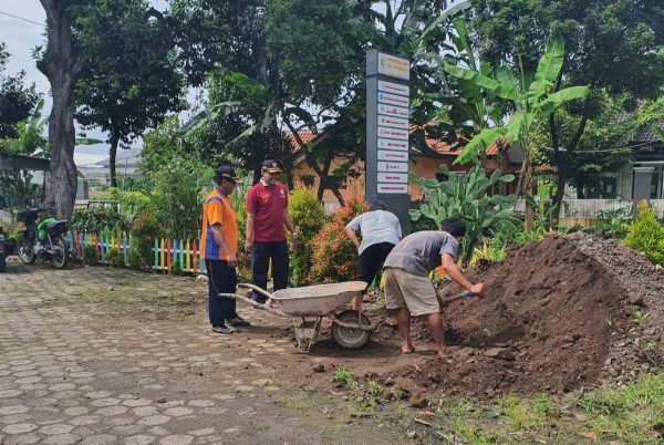 Perangkat Desa Pucangrejo, membersihkan sisa material di samping gerbang Balaidesa