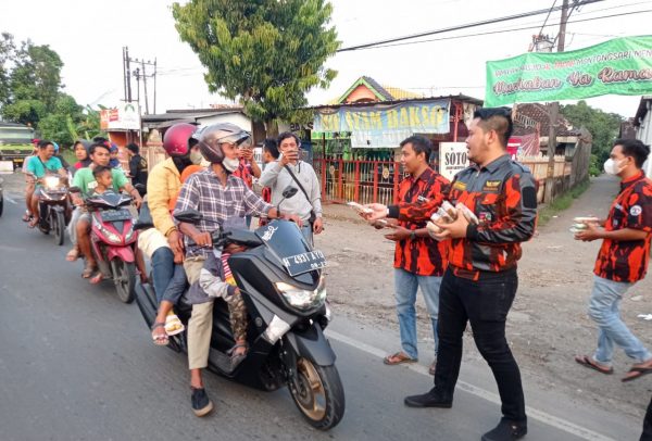 Ketua PP Weleri Rizky Aritonang membagikan takjil kepada para pengendara