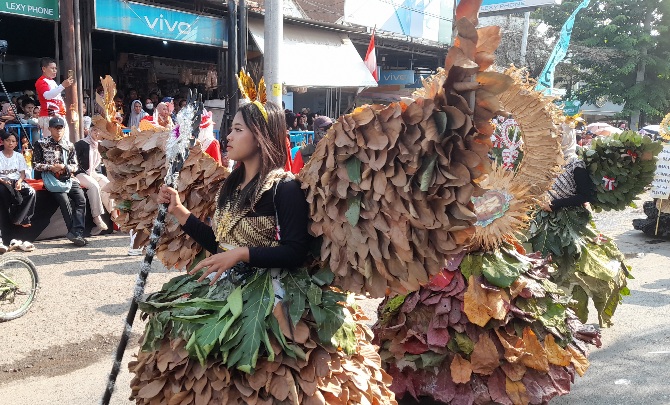Penampilan peserta karnaval dengan kreasi busana dari dedaunan